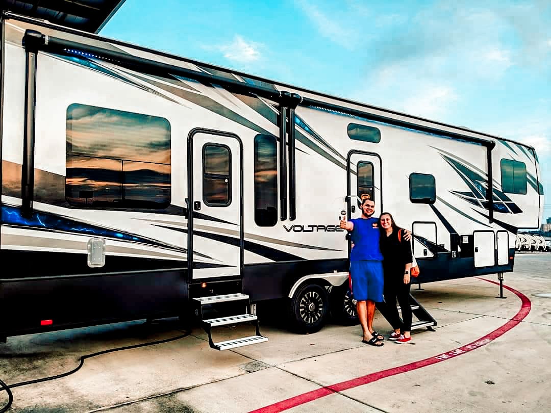 Couple posing in front of newly purchased fifth wheel