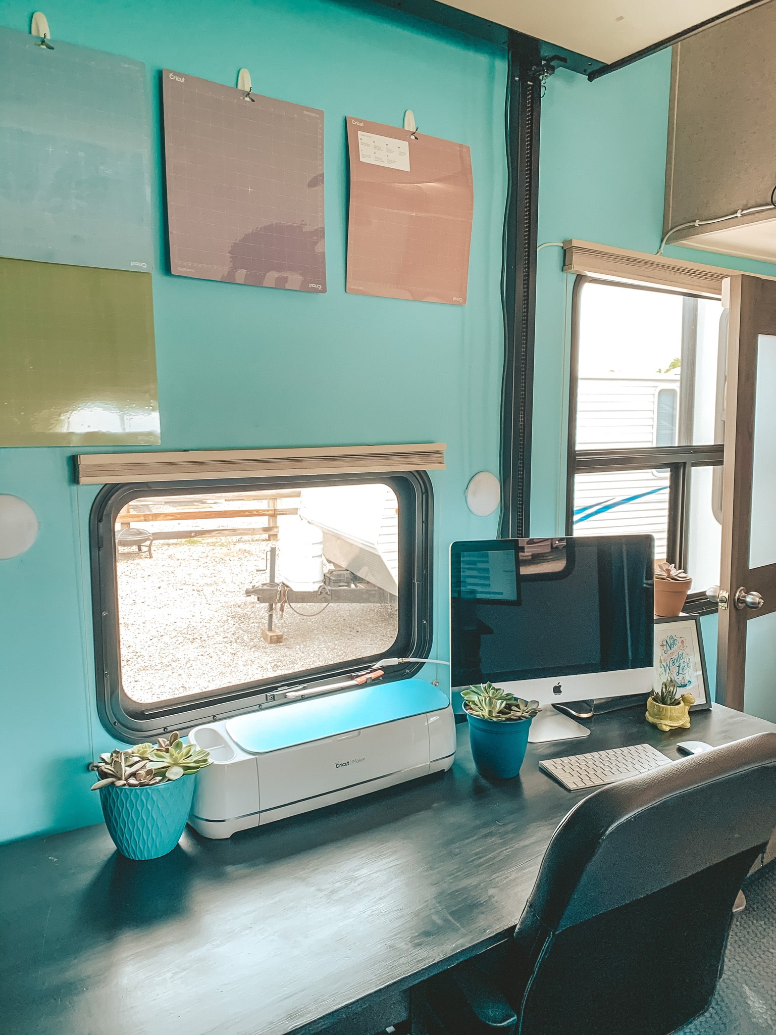 RV office desk with cutting mats hanging on wall