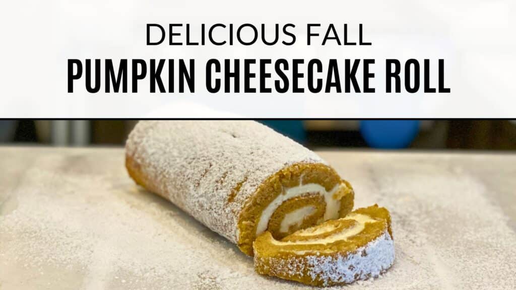 Pumpkin Cheesecake roll with a slice cut off at the end sprinkled with powdered sugar. Text on the image says " Delicious Fall Pumpkin Cheesecake Roll"