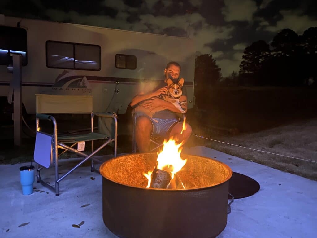 Man and dog hanging out around fire pit