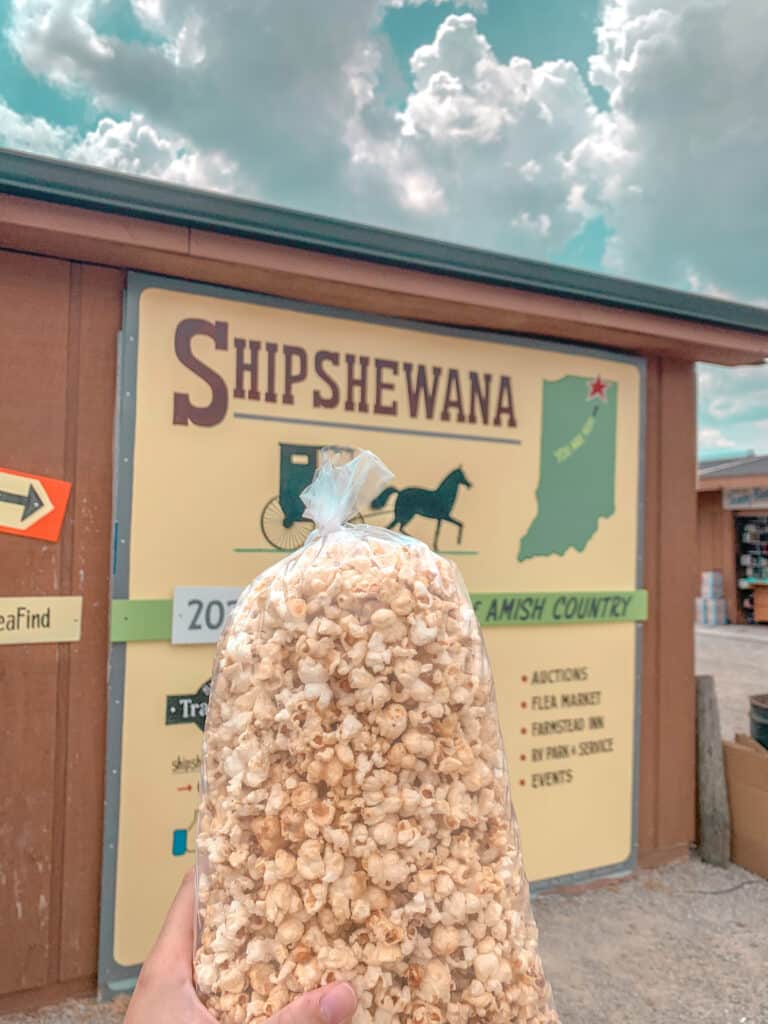 Bag of kettle corn popcorn in front of Shipshewana sign