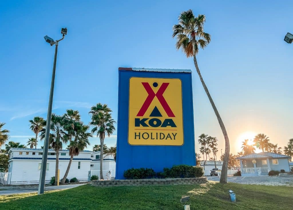 South Padre Island KOA Holiday Sign with sun setting and palm trees in background