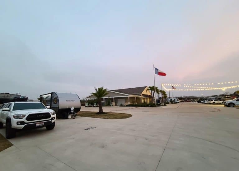 Travel trailer parked in RV site next to clubhouse at Jet Stream RV Resort - Tropical Trails in Brownsville, Texas.