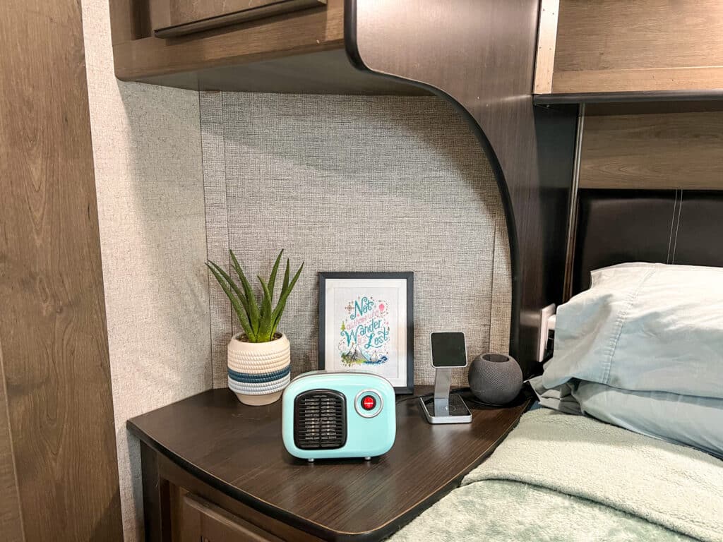 A fake aloe vera plant sits on a nightstand in an RV bedroom.