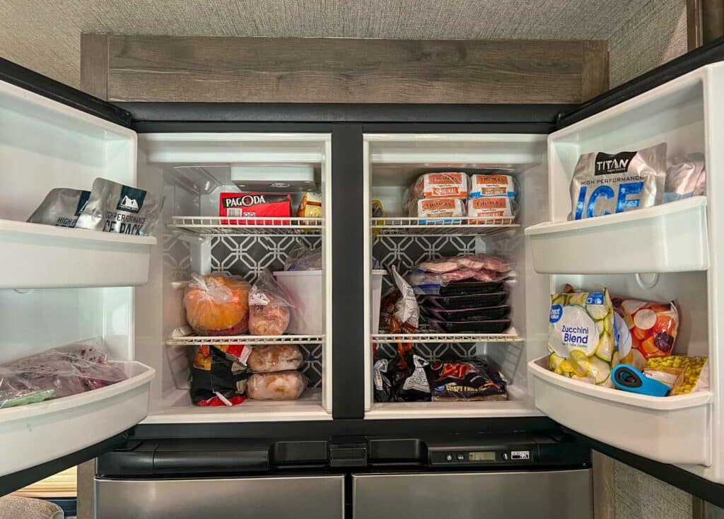A double door freezer is defrosted, cleaned, and restocked with food.