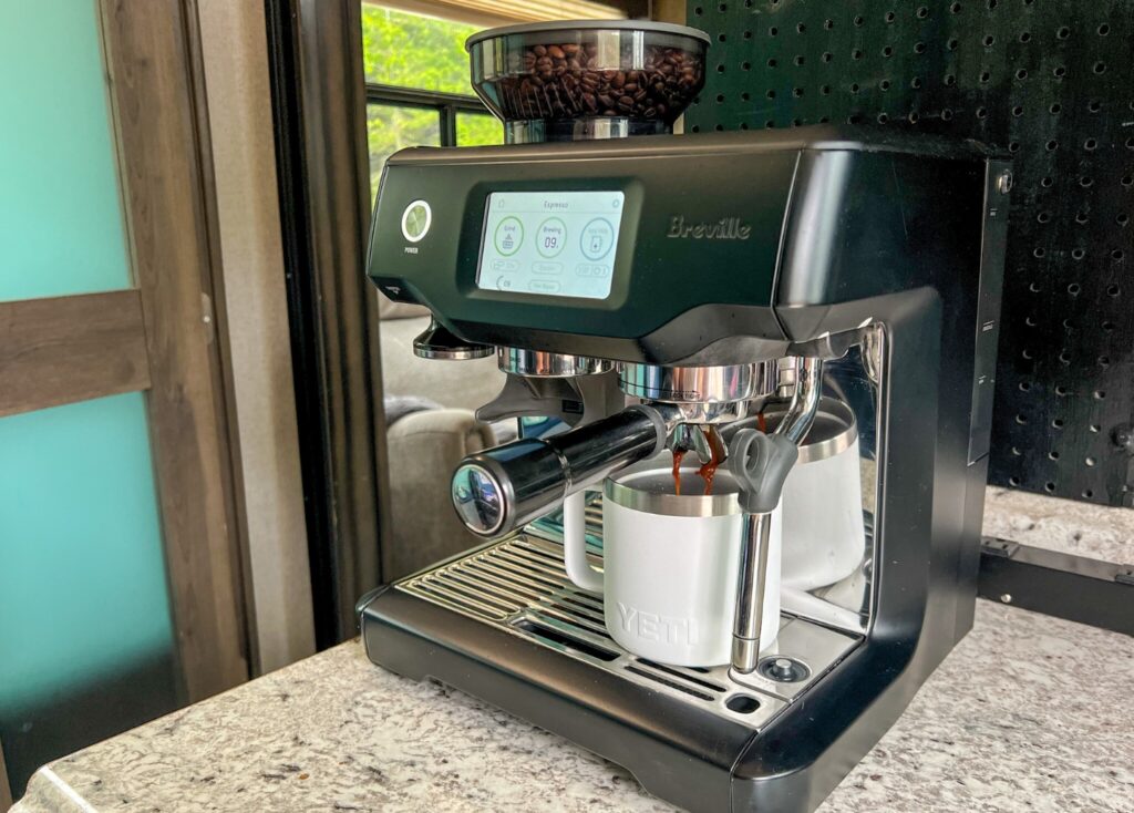 Breville Barista Touch espresso machine brewing coffee over a white Yeti coffee mug. 