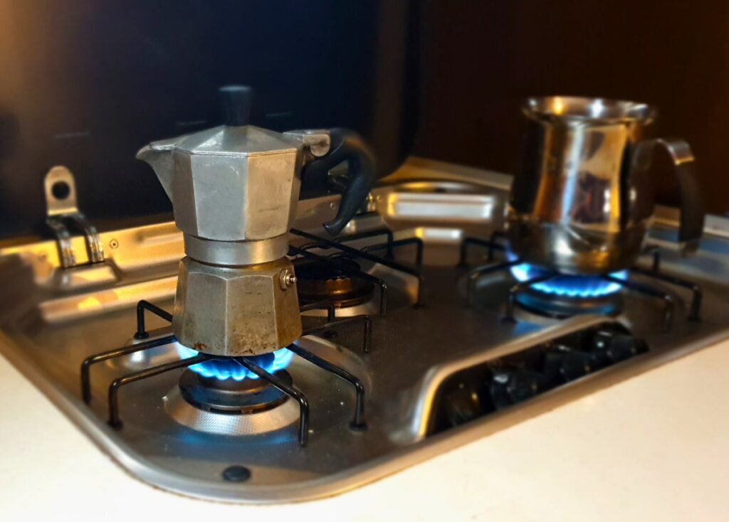 Moka pot brewing on propane burner inside a camper van. 