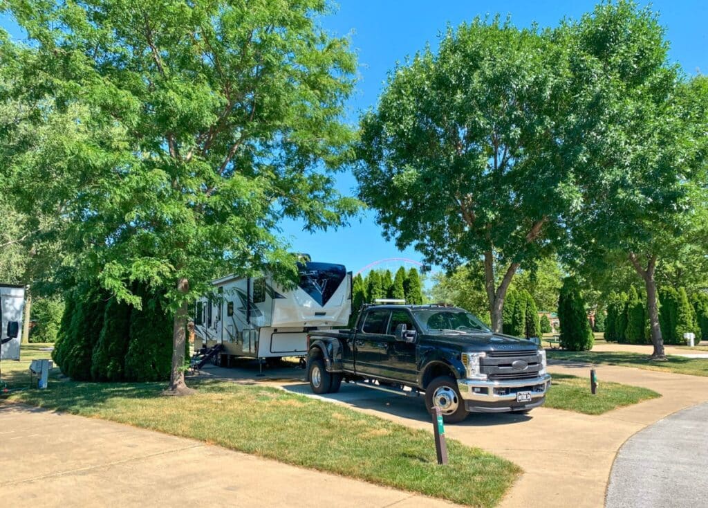 A fifth wheel and black truck parked in an RV campsite at the Cedar Point Campground.