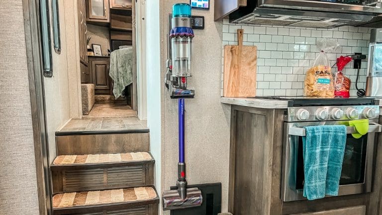 Dyson stick vacuum hanging on wall of RV