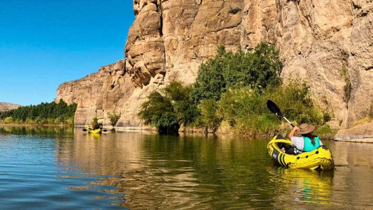 Woman paddling inflatable kayak on a river