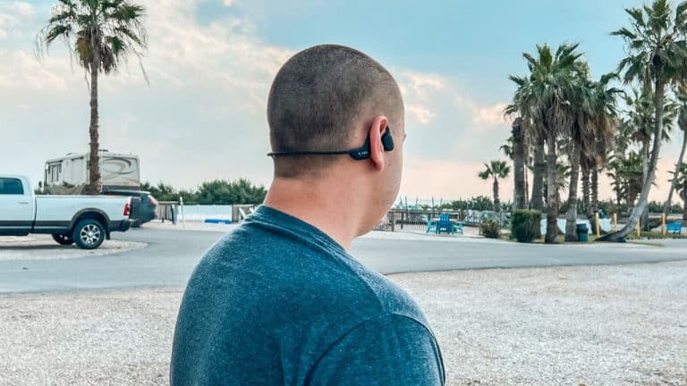 Man wearing shokz over ears headphones