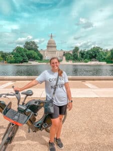 woman standing next to bike in front of Capitol in D.C.
