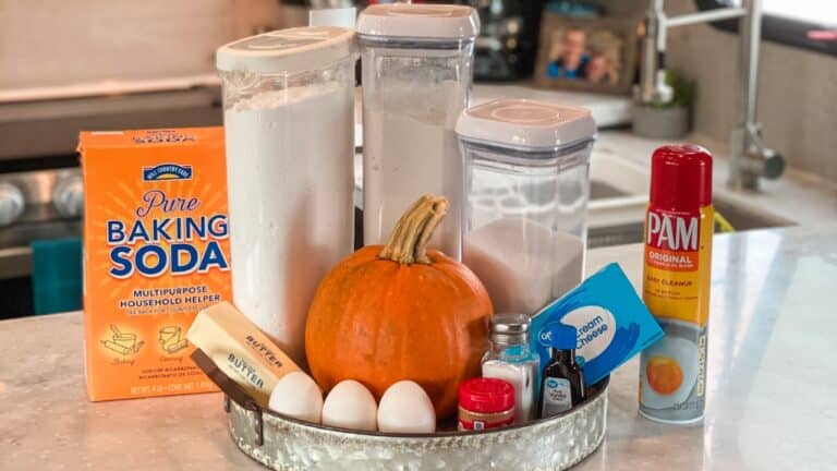 Thanksgiving baking ingredients on kitchen counter with pumpkin in the middle