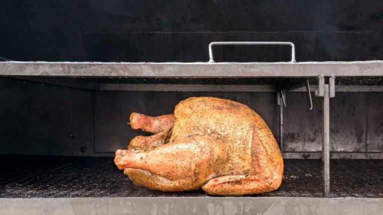 Cooked whole turkey inside a smoker grill