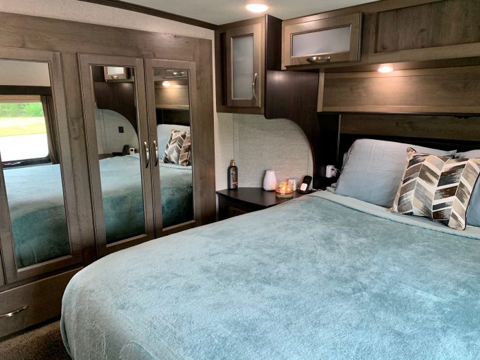 RV bedroom. Teal bedspread with candle lit on side table