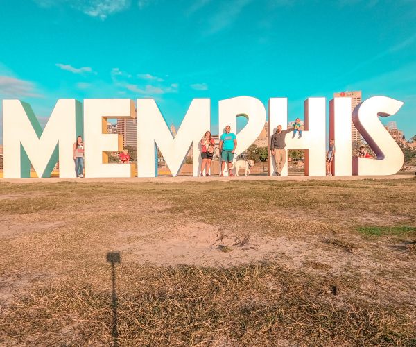 Family standing in front of giant sized Memphis sign