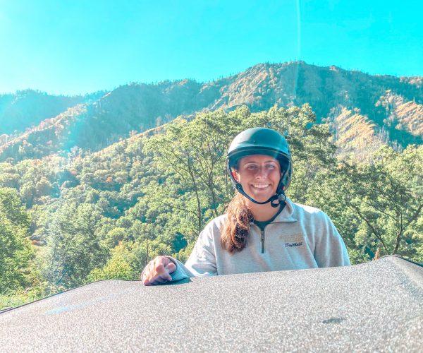 Woman wearing motorcycle helmet in front of mountains